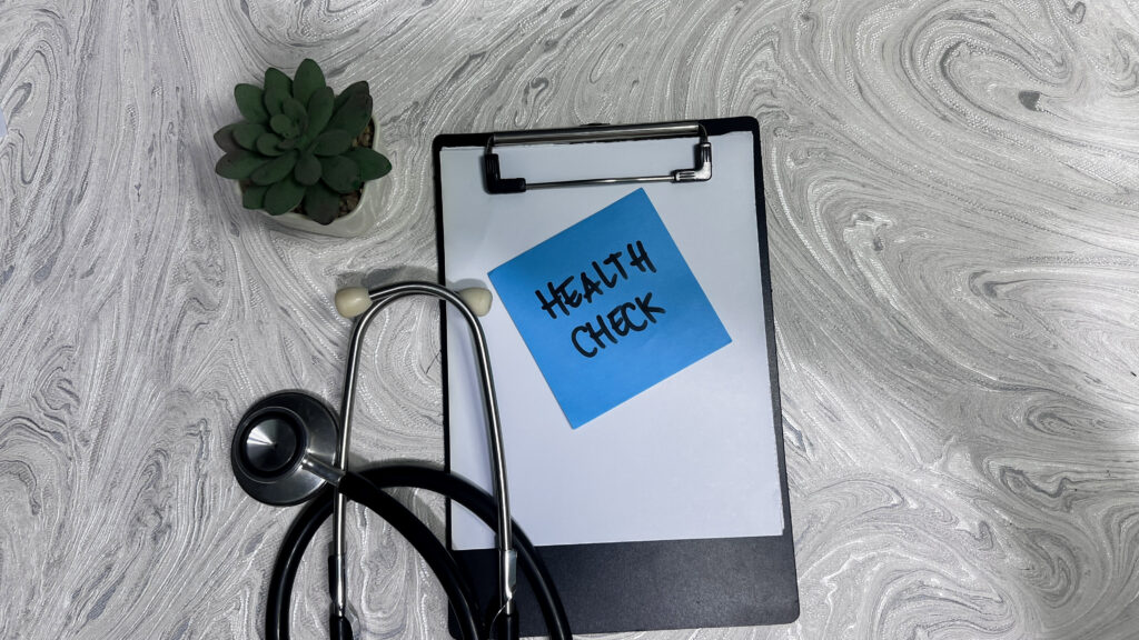 concept of health check write on sticky notes isolated on wooden table.